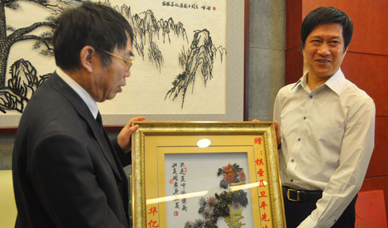 華億集團董事長項義水向聶衛平贈送蕪湖特色工藝品“鐵畫”