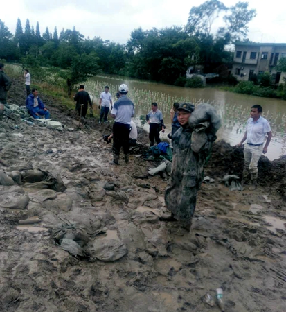 徐勇在防洪大堤上扛沙袋